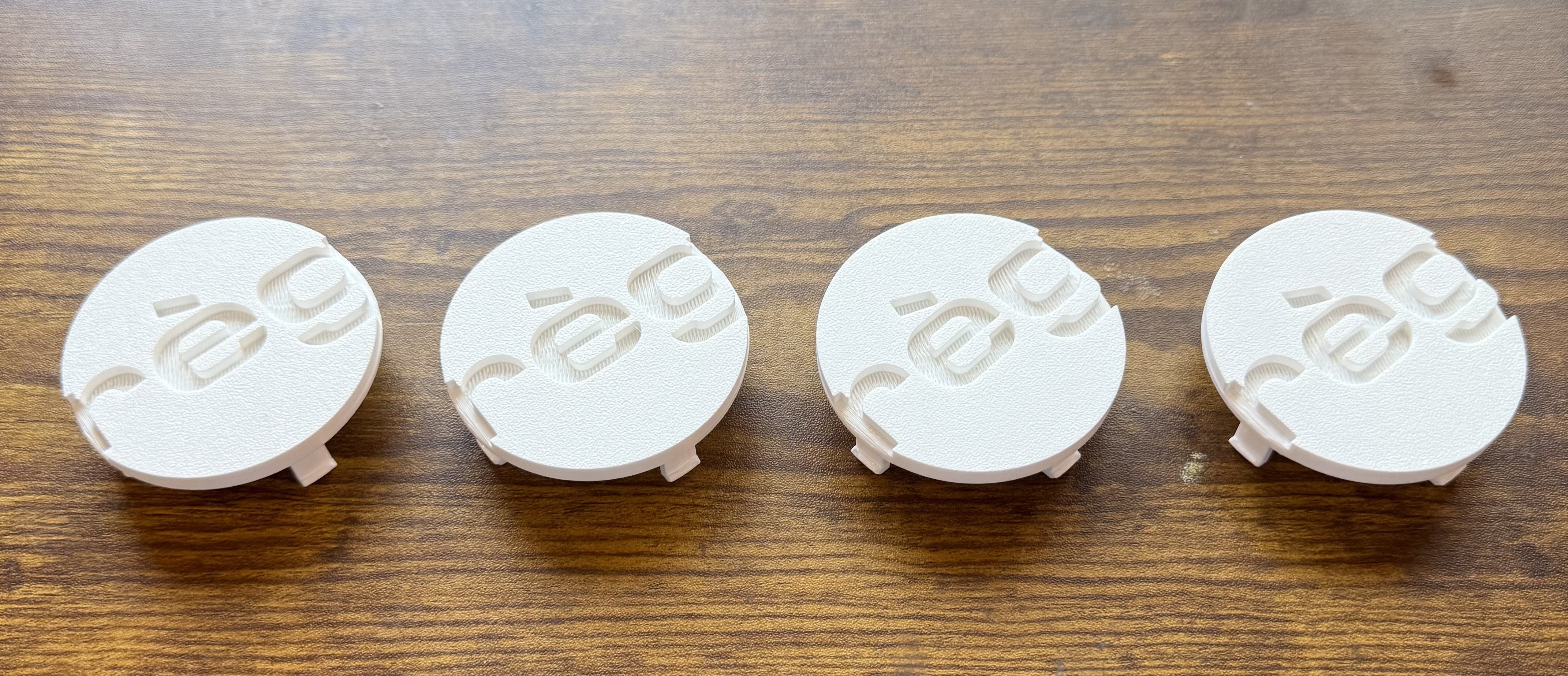 Four white PETG prototype wheel center caps